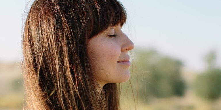 Close up profile view of a woman outside meditating with eyes closed